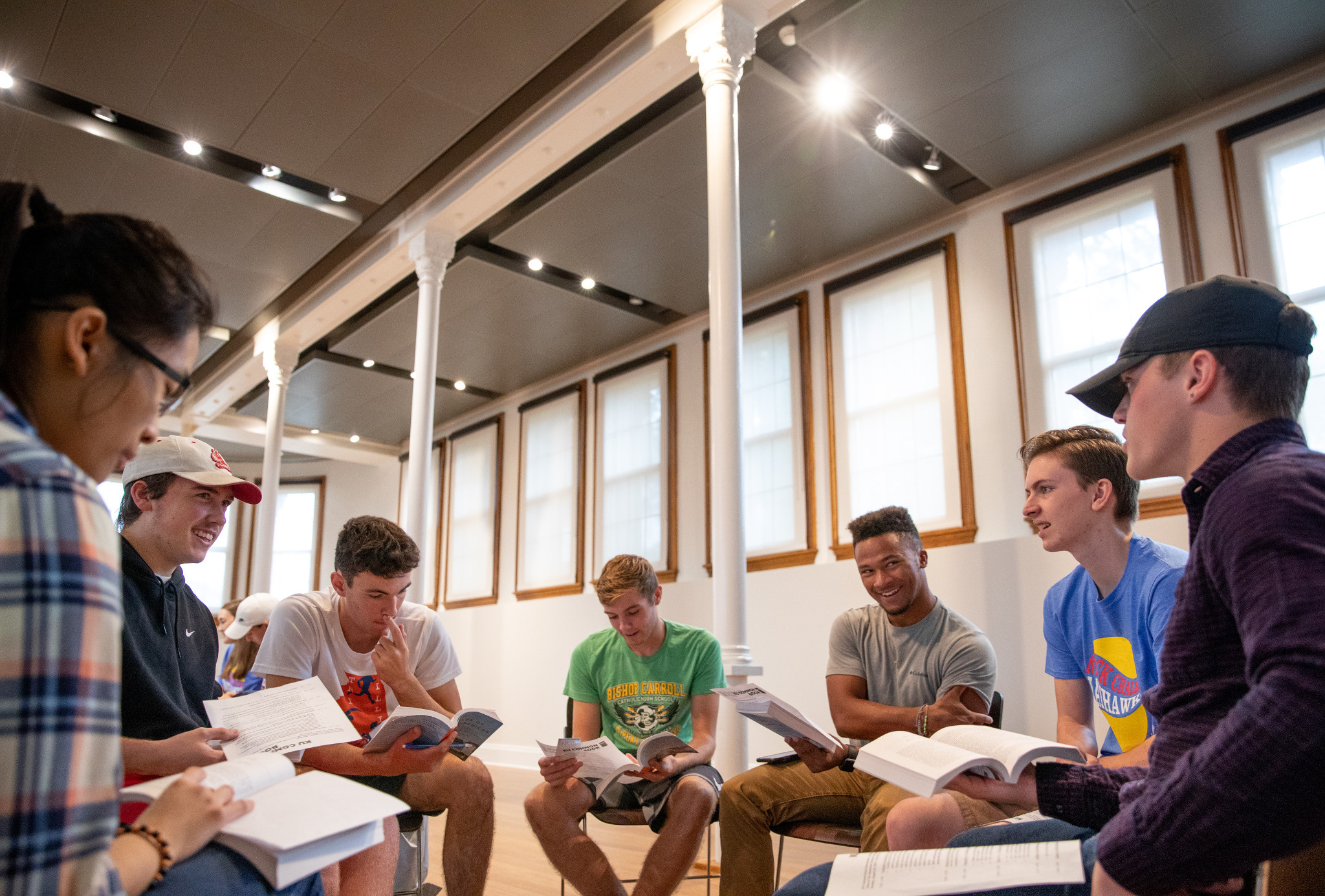 A group of diverse students in collaboration with book in their hand