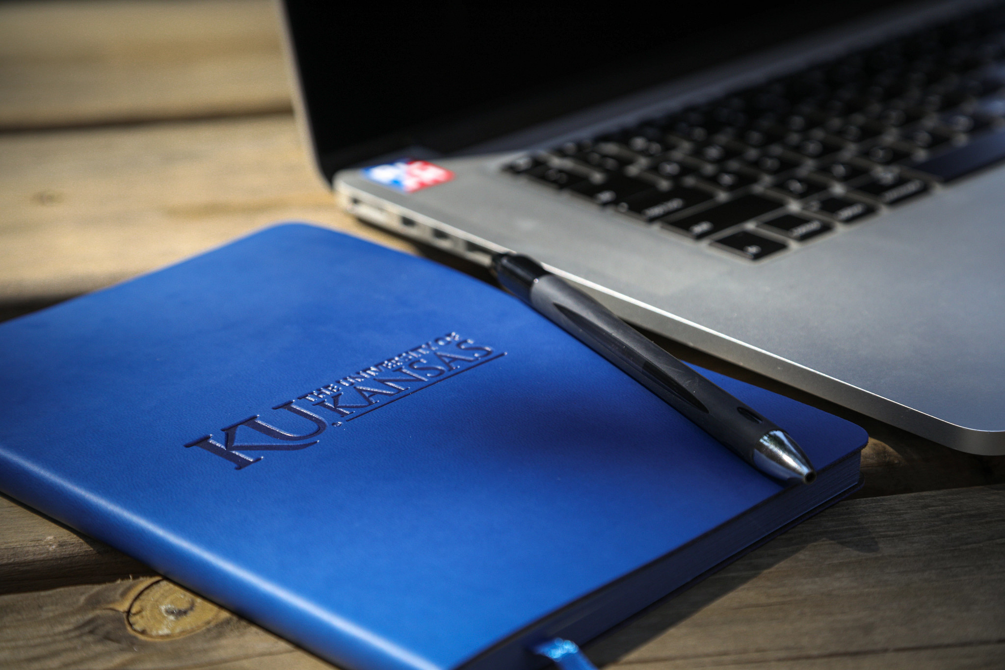 A blue KU notebook and laptop